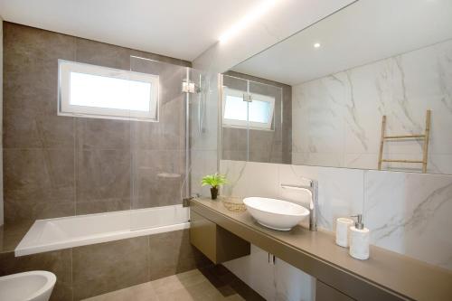 een badkamer met een wastafel, een toilet en een bad bij Luxury Boho Style Apartment Nazaré in Nazaré