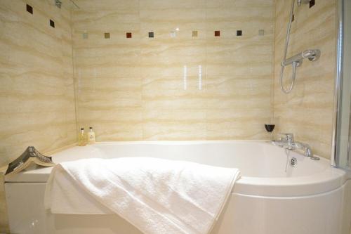 ein Badezimmer mit einer weißen Badewanne und einer Dusche in der Unterkunft Red Robin, Whepstead in Whepstead