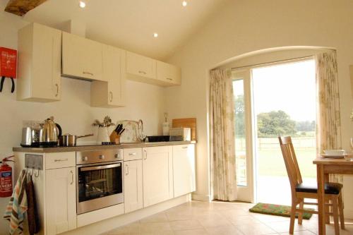 a kitchen with white cabinets and an open door at Romulus 