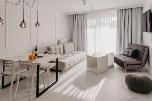 a white living room with a table and a couch at Norwida 17 in Międzyzdroje