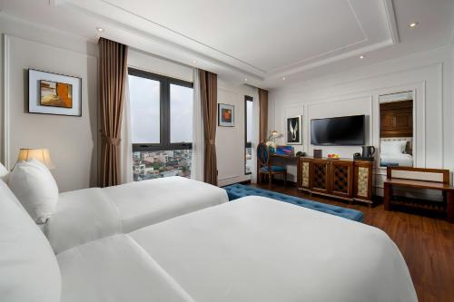 a hotel room with two beds and a television at The Q Hotel in Hanoi