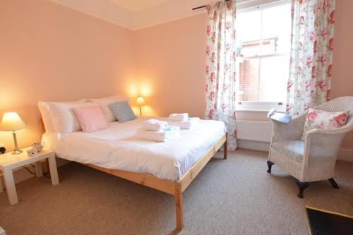 a bedroom with a bed and a chair and a window at Lavender House, Aldeburgh in Aldeburgh