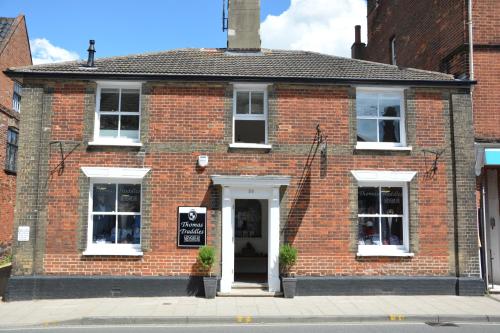 a red brick building with a sign on the door at Southwold Arms Apartment in Southwold