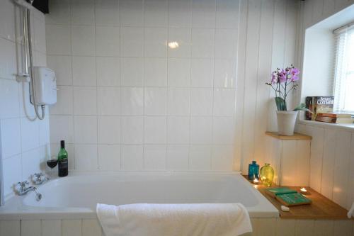 a white bath tub in a bathroom with a window at 1 Grange Cottages, Westleton in Westleton