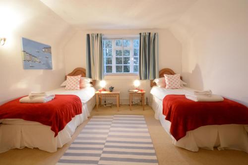a bedroom with two beds with red and white sheets at Rippleway, Walberswick in Walberswick