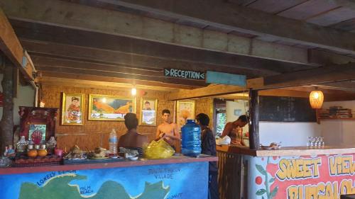 eine Gruppe von Menschen, die an einem Essensstand stehen in der Unterkunft Sweet jungle sea view bungalows in Sihanoukville