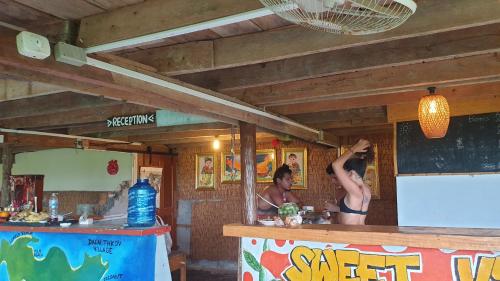 two men standing at a counter in a restaurant at Sweet jungle sea view bungalows in Sihanoukville