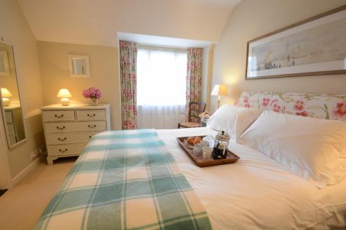 a bedroom with a bed with a tray of food on it at 2 The Bays, Thorpeness in Thorpeness