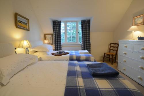 a bedroom with two beds and a dresser at 2 The Bays, Thorpeness in Thorpeness