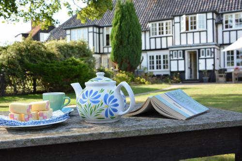 a table with a tea pot and a book at 2 The Bays, Thorpeness in Thorpeness