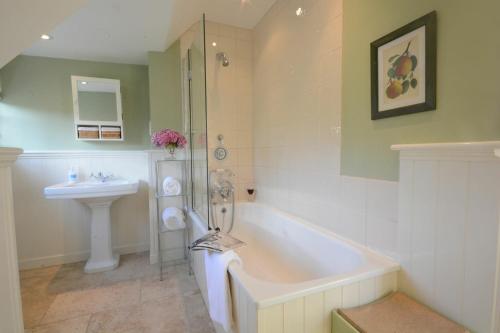 ein Badezimmer mit einer Badewanne und einem Waschbecken in der Unterkunft 2 The Bays, Thorpeness in Thorpeness