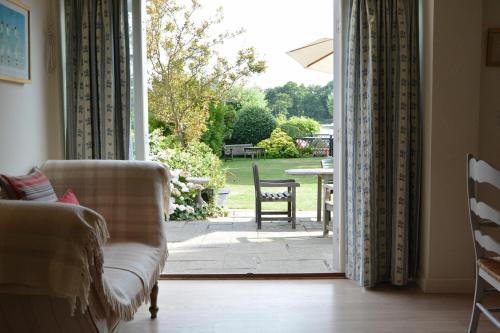 an open door to a patio with a table and chairs at 2 The Bays, Thorpeness in Thorpeness
