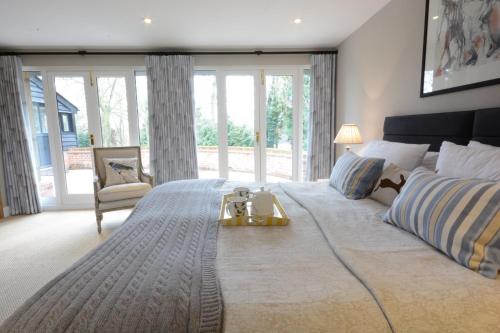 a large bedroom with a large bed with a table on it at Bird Cottage, Burgh in Grundisburgh