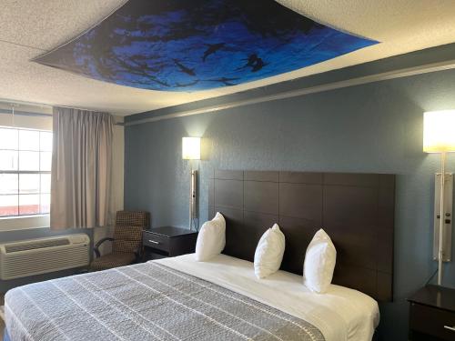 a bedroom with a bed with a blue painting on the ceiling at KINGS INN- Medical Downtown Midtown Memphis in Memphis