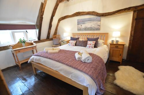 a bedroom with a large bed with two stuffed animals on it at Pudding Cottage, Westleton in Westleton