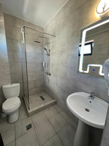 La salle de bains est pourvue d'une douche, de toilettes et d'un lavabo. dans l'établissement Hotel AMA WORLD, à Constanţa