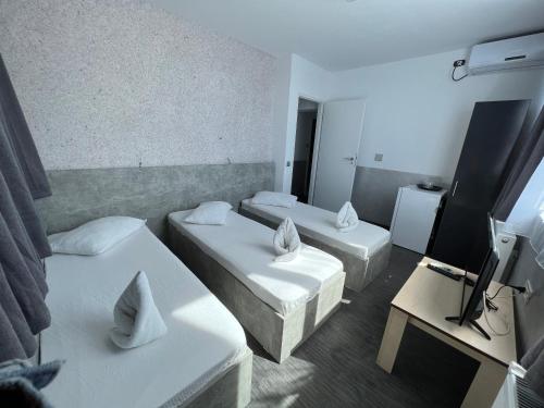 Cette petite chambre comprend deux lits et une télévision. dans l'établissement Hotel AMA WORLD, à Constanţa