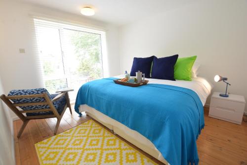 een slaapkamer met een bed, een stoel en een raam bij Aldeburgh Lodge Gardens in Aldeburgh