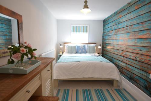 um quarto com uma cama e uma parede de madeira em Alinka, Aldeburgh em Aldeburgh