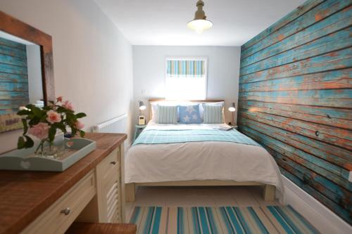 Un dormitorio con una cama y una pared de madera. en Alinka, Aldeburgh, en Aldeburgh