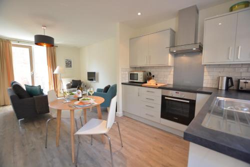 a kitchen and living room with a table and chairs at Mycroft, Southwold in Southwold