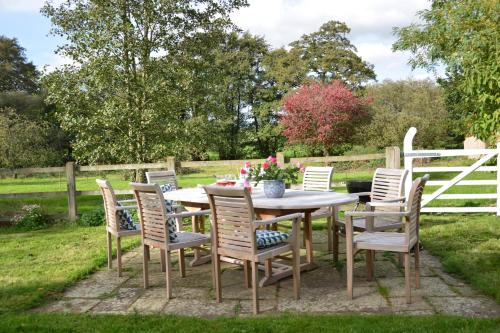 a table and chairs with flowers on it in a yard at Wheelwright's Barn in Halesworth
