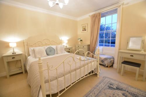 a bedroom with a white bed and a window at Henstead Hall in Beccles
