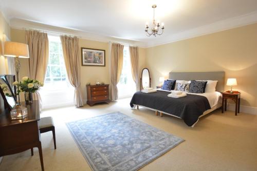 a bedroom with a bed and a chandelier at Henstead Hall in Beccles