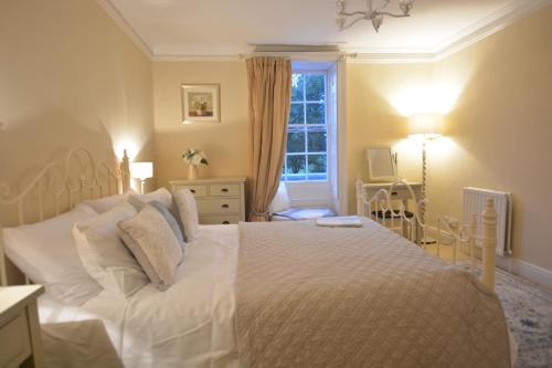 a bedroom with a large white bed and a window at Henstead Hall in Beccles