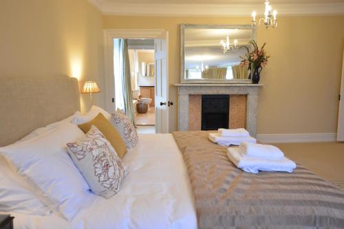 a bedroom with a white bed with towels on it at Henstead Hall in Beccles