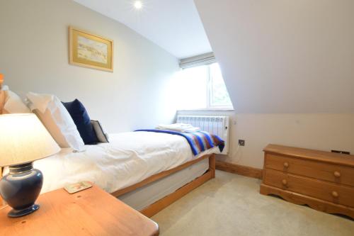 a bedroom with a bed and a table with a lamp at 1 Tunns Cottages, Rushmere, nr Beccles in Beccles