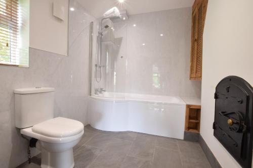 a bathroom with a toilet and a bath tub at 1 Tunns Cottages, Rushmere, nr Beccles in Beccles