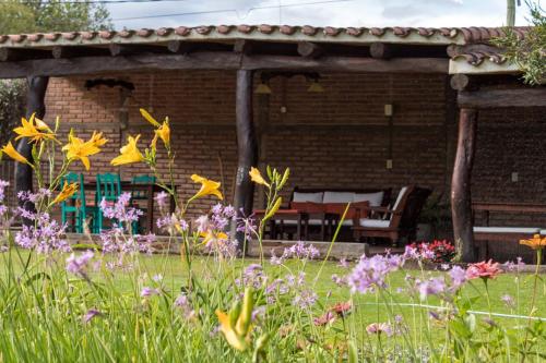 a garden with flowers in front of a pavilion at Casa del Sol Cafayate in Cafayate