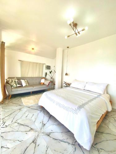 a bedroom with a large bed and a couch at Bintana sa Paraiso Binunsaran in Mambajao