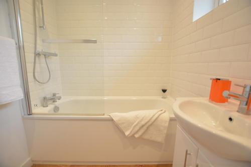 a white bathroom with a tub and a sink at Field Edge, Tunstall in Tunstall