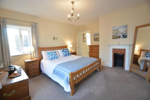 - une chambre avec un grand lit et une cheminée dans l'établissement Gosfield Cottage, Aldeburgh, à Aldeburgh