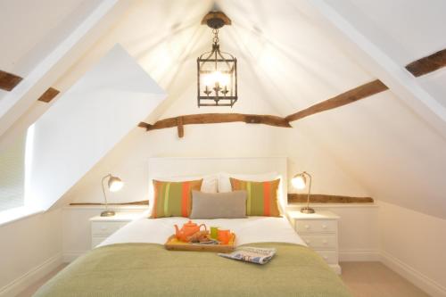 ein Schlafzimmer mit einem Bett im Dachgeschoss in der Unterkunft Carriage House, Bruisyard in Framlingham