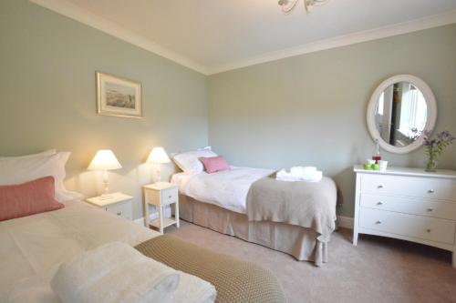 een kleine slaapkamer met 2 bedden en een spiegel bij Mowbrays, Middleton in Middleton