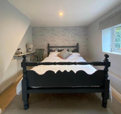 a bedroom with a large black bed in a room at The Sail Loft in Kingsbridge