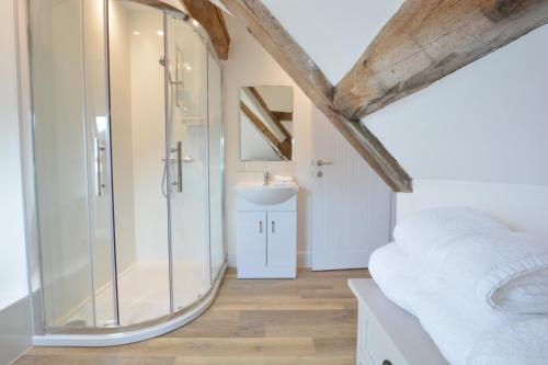 a bathroom with a glass shower and a sink at Ploughman's Green, Blythview in Blythburgh