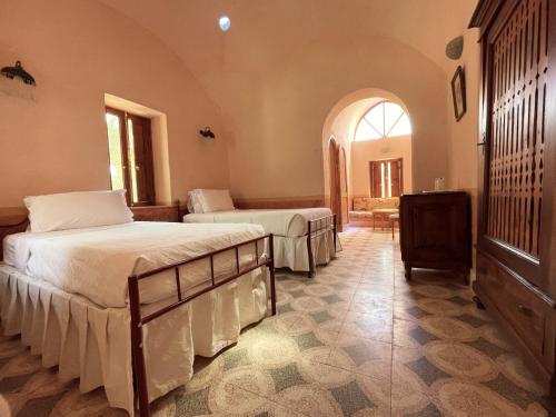 a bedroom with two beds and a dresser in it at Al Moudira Hotel in Luxor