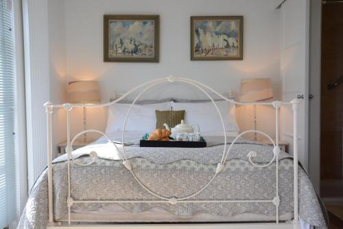 a white bed with a white frame in a bedroom at Robert Sadler's Studio in Aldeburgh