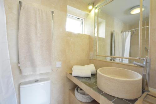 a bathroom with a sink and a toilet and a mirror at Robert Sadler's Studio in Aldeburgh