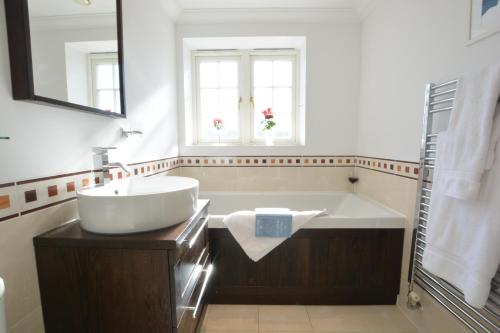 a white bathroom with a tub and a sink at Neptune in Aldeburgh