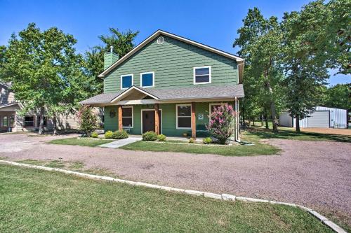a green house with a driveway at Kingston Home with Pickleball Steps to Lake Texoma! in Kingston
