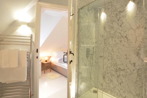 a bathroom with a shower with a glass door at The Round House in Kettleburgh