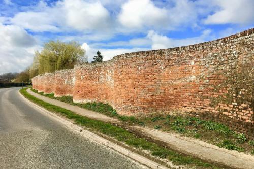 a brick wall on the side of a road at The Round House in Kettleburgh