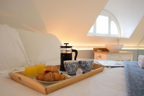 ein Tablett mit Croissants und Orangensaft auf dem Bett in der Unterkunft The Round House in Kettleburgh