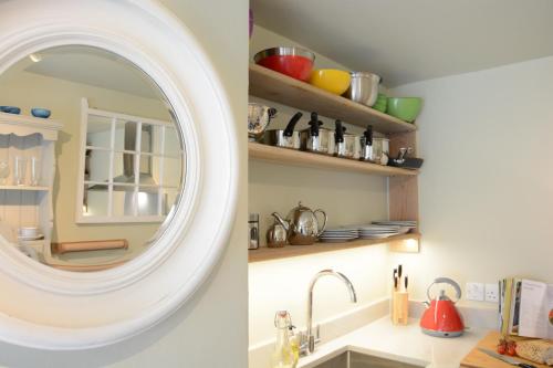 a kitchen with a mirror above a sink at Church Farm Cottage, Dunwich in Westleton