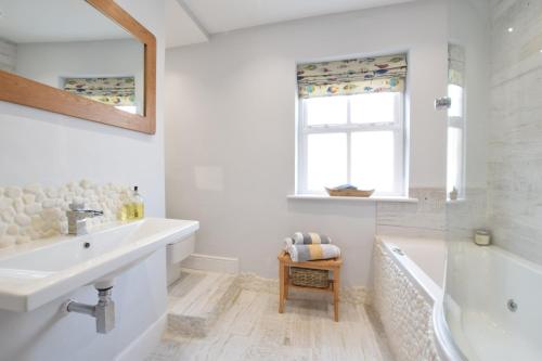ein Badezimmer mit Waschbecken, Badewanne und Fenster in der Unterkunft 53 Tern Cottage, Aldeburgh in Aldeburgh